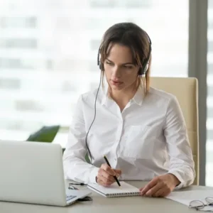 a woman taking notes from the laptop