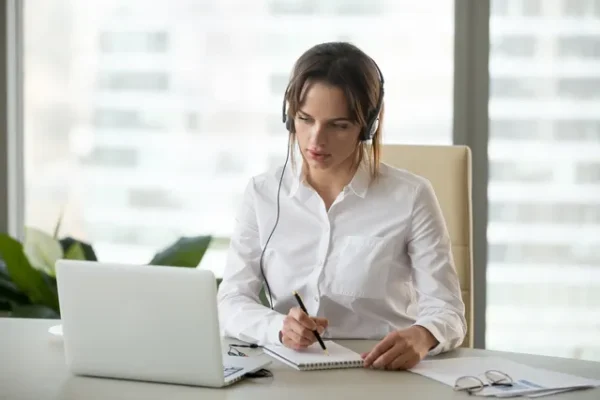 a woman taking notes from the laptop